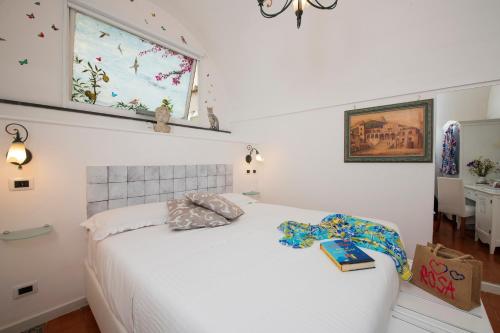 a bedroom with a white bed and a window at ApartHotel Antica Repubblica in Amalfi center at 100mt from the sea in Amalfi
