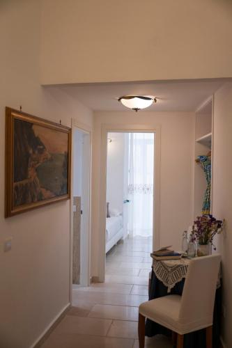 a living room with a table and a painting on the wall at ApartHotel Antica Repubblica in Amalfi center at 100mt from the sea in Amalfi