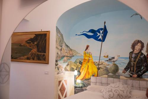 a mural on the wall of a bedroom with a flag at ApartHotel Antica Repubblica in Amalfi center at 100mt from the sea in Amalfi