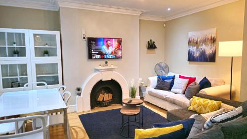 a living room with a couch and a fireplace at Stylish 2 Bedroom Apartment, Leeds Centre + Free Parking in Leeds