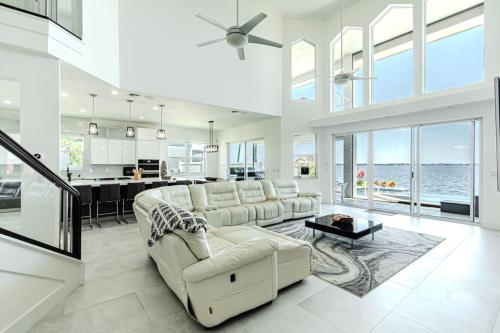 a large white living room with a couch and a table at Breathtaking 6BD Riverfront Mansion w Pool in Cape Coral