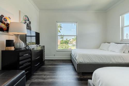 une chambre avec deux lits et une commode et une fenêtre dans l'établissement Breathtaking 6BD Riverfront Mansion w Pool, à Cape Coral