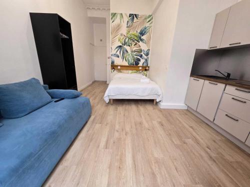 un salon avec un canapé bleu et une cuisine dans l'établissement Studio Opera, à Paris