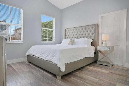 a white bedroom with a large bed and a window at 5BD, 5BA, Tropical Oasis, Pool, Patio and Fun in Hialeah