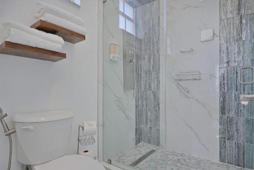 a white bathroom with a shower and a toilet at 5BD, 5BA, Tropical Oasis, Pool, Patio and Fun in Hialeah