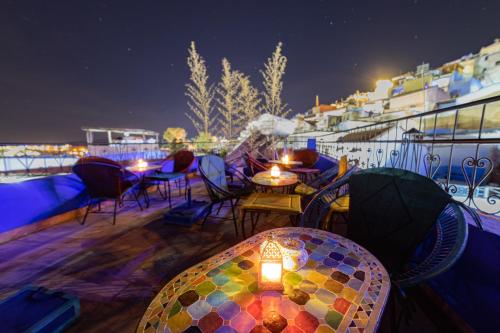 a patio with a table and chairs and lights at Iguana Azul in Chefchaouene