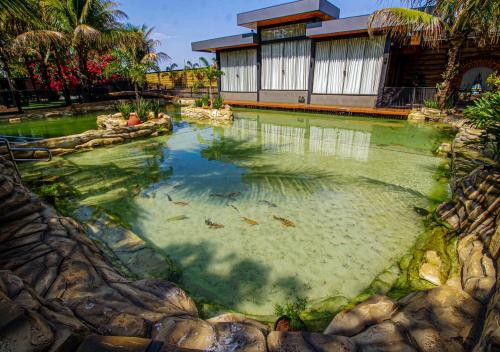 a pool of water in front of a house at Carpe Diem Eco Resort Olímpia in Olímpia