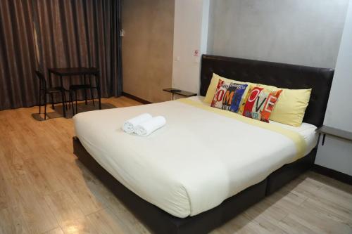 a bedroom with a large bed with a white sheets and pillows at Bkk39 Airport hotel in Ban Khlong Prawet
