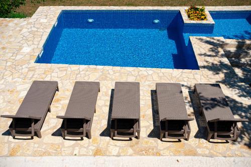 a group of lounge chairs and a swimming pool at ZEN Relaxing Village in Cetinje