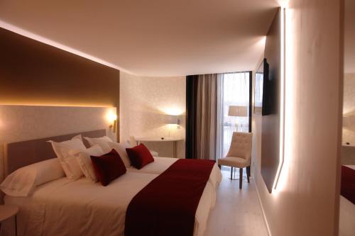a hotel room with a large bed and a window at Hotel Cardenal in Monforte de Lemos