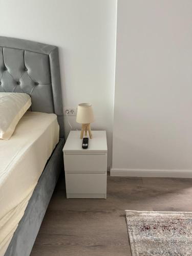 a bedroom with a bed with a lamp on a nightstand at Studio Kiki by the Lujerului metro station in Bucharest