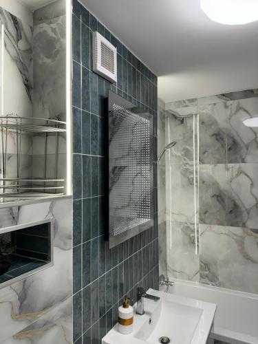 a bathroom with a sink and a shower at Studio Kiki by the Lujerului metro station in Bucharest