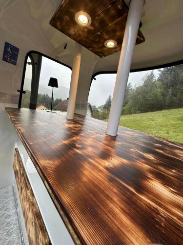 a wooden table on the back of a boat at Chalet L'Élégance - SPA - Serviettes - Peignoirs - Lits faits - Ménage inclus in Rochesson