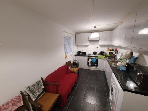 a living room with a red couch in a kitchen at egHoliday in London