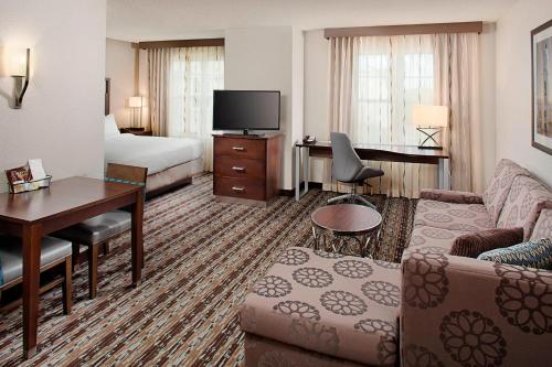 a hotel room with a bed and a couch and a desk at Residence Inn Worcester in Worcester