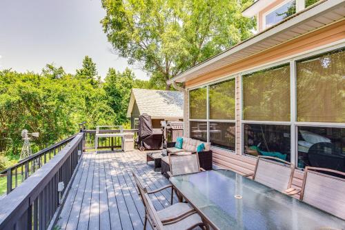 an outdoor deck with a glass table and chairs at Lake Holbrook Waterfront Vacation Rental with Dock! in Mineola