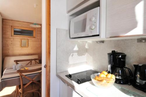 une cuisine avec un bol de fruits sur un comptoir dans l'établissement Résidence Agate - Studio pour 4 Personnes 35, à Mâcot La Plagne