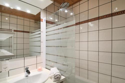 une salle de bain avec un lavabo et une douche avec un miroir dans l'établissement Résidence Agate - Studio pour 4 Personnes 35, à Mâcot La Plagne
