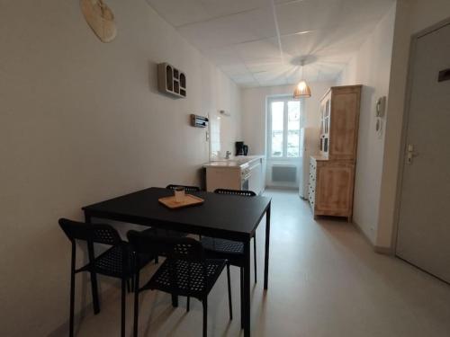 a kitchen with a table and chairs in a room at Appartement centre Descartes in Descartes