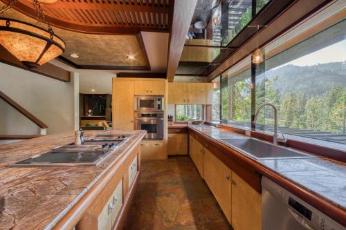a kitchen with a sink and a large window at Spire Chalet at Alpine Meadows - 4BR W Hot Tub and Ski Shuttle in Alpine Meadows