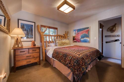 a bedroom with a bed and a dresser and a lamp at Spire Chalet at Alpine Meadows - 4BR W Hot Tub and Ski Shuttle in Alpine Meadows