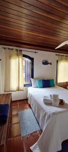 a bedroom with a large bed with a wooden ceiling at Pousada Manga Rosa in Paraty