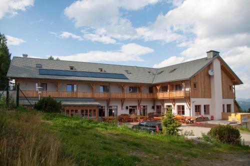 a large house with a gambrel roof at JUFA Hotel Hochrindl in Hochrindl