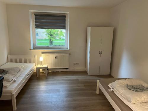 a bedroom with two beds and a window at Wohnen am Wasserschloss Sandizell in Schrobenhausen