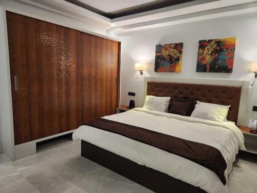 a bedroom with a large bed and a large wooden door at BLUE ANGEL Guest House in Shillong