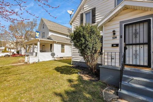 a white house with a yard in front of it at Spacious 3 Bedroom, 4Bed Cozy Home in Lansing