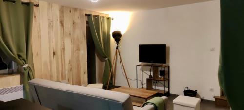 un salon avec un canapé et une télévision dans l'établissement Appartement 2 chambres avec WIFI Centre de Descartes, à Descartes