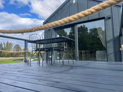 two chairs and a table on a patio at Holiday Hill Karpnki, Sauna, Domek Hygge-balia, Domek Lagom-jacuzzi in Karpniki