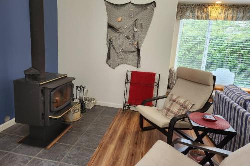 a living room with a wood stove and chairs at Stars, Stripes, and Sand in Neskowin