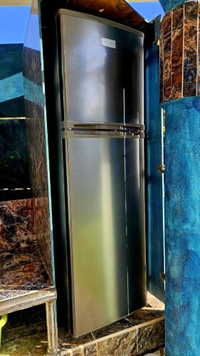 a metal refrigerator in a room with a wall at Sunset Samana in Las Galeras