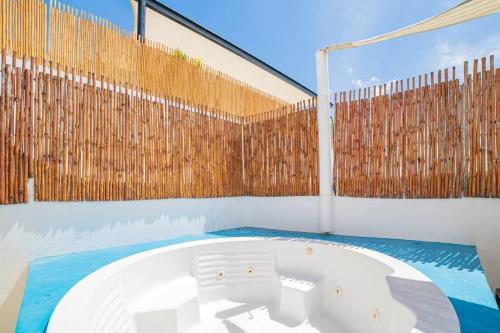 a hot tub in a room with a wooden fence at papaya 15 Exclusive PentHouse with rooftop and jacuzzi in Playa del Carmen