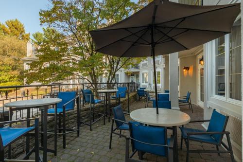 a patio with tables and chairs and an umbrella at Holiday Inn Express & Suites Tremblant by IHG in Mont-Tremblant