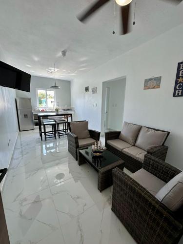 a living room with couches and a table and a kitchen at Sunrise ApartaHotel in El Manguito