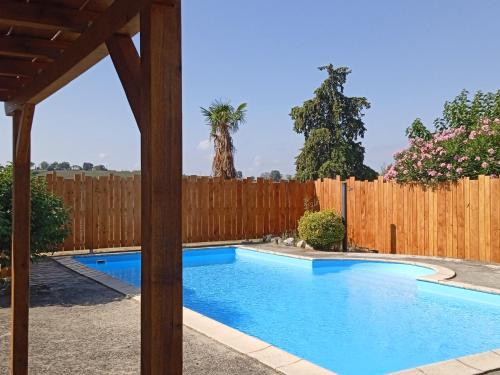- une piscine dans un jardin avec une clôture en bois dans l'établissement La glycine, à Verfeil