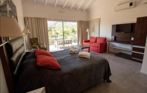 a bedroom with a large bed and a living room at Rumbo 020 Apart in Merlo