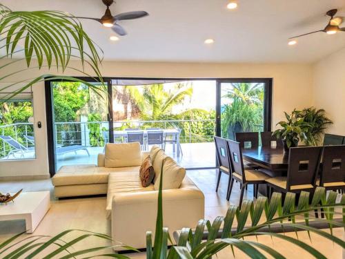 Modern Beach Villa Pool Ocean Views Terrace BBQ Villa Vista Real في بلايا ديل كارمن: غرفة معيشة مع أريكة وغرفة طعام