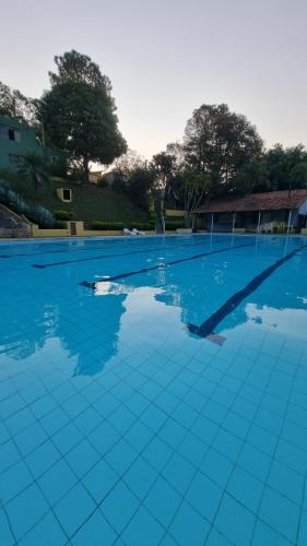 a large swimming pool with blue tiles on it at Chalé do Lago in Pirapitingui