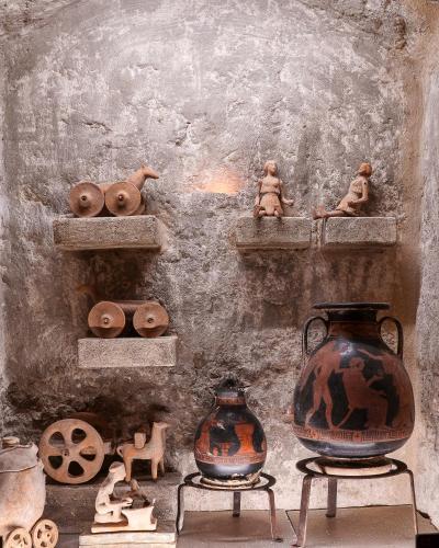 a display of vases and other items on shelves at MOYSEION Matera - Immersion in a distant past in Matera