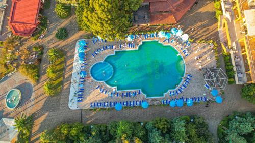 an overhead view of a large swimming pool with blue umbrellas at Dreamlend oasis chakvi Apartament in Chakvi