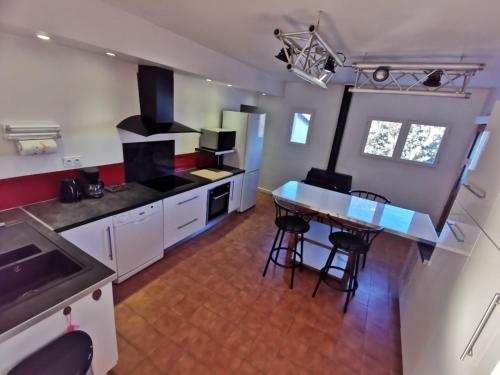 une grande cuisine avec une table et des chaises. dans l'établissement Le petit Vialto, à Grospierres