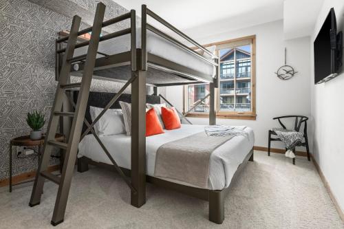 - une chambre avec des lits superposés et des oreillers orange dans l'établissement NEW Spacious MTN View Condo, PRIME location with Hot Tub, Free National Park Pass, Huge Patio, BBQ, Sleeps 7, à Canmore