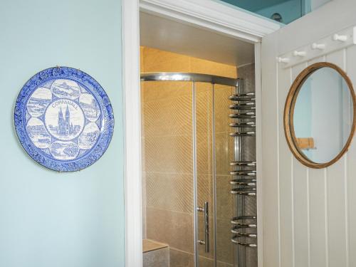 Un baño con ducha y una placa en la pared. en Zawn Nook, en Falmouth
