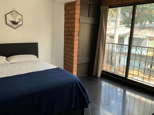 een slaapkamer met een bed en een balkon bij Aparta Suite Torre De Prado 301 in Medellín