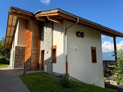 une maison blanche avec un toit en bois dans l'établissement Chalet Petit Val, à Combloux
