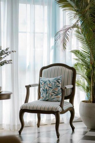 a chair with a pillow sitting in front of a window at Villa Đà Lạt Khởi Nghĩa Bắc Sơn Gần Hồ Xuân Hương Gần Chợ Đêm - KNBS Lana in Xuan An