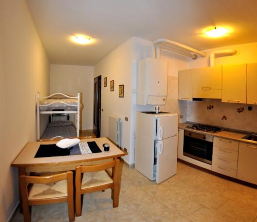 Una cocina con una mesa y un refrigerador blanco. en La Magnolia, en Verona